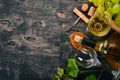 A bottle of white wine with glasses and grapes. Leaves of grapes. Top view. On a black wooden background. Royalty Free Stock Photo