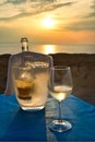 Bottle of white wine, in the ice bucket with a glass alongside, at sunset by the sea in Italy. Royalty Free Stock Photo