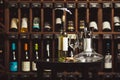 Bottle of white wine on the table next to decanter and glasses over shelf background.