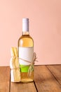 A bottle of white wine with a tied piece of cheese. Suitable food concept, couple. Creative.