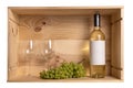 A bottle of white wine, two wine glasses and white grapes in a wooden box from wine bottles Royalty Free Stock Photo