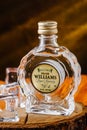 A bottle of Williams pear brandy on a black and orange background