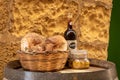 Bottle of wine, artisan bread in wicker basket and marinated cheese on a wooden barrel. Traditional food products of Malta. Royalty Free Stock Photo