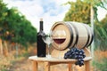Bottle of wine, barrel and glasses on wooden table Royalty Free Stock Photo