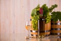 Bottle of wine with barrels grapes and grapeleaves Royalty Free Stock Photo