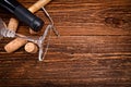 Bottle of wine, corkscrew and corks on wooden table. Background