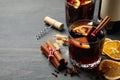 Bottle of wine, cups of mulled wine and ingredients on wooden background