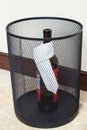 Bottle wine in an empty trash can Royalty Free Stock Photo