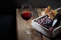 A bottle of wine, a glass, a bunch of grapes and grape leaves on an old wooden table Royalty Free Stock Photo