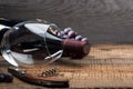 A bottle of wine, a glass, a bunch of grapes and grape leaves on an old wooden table Royalty Free Stock Photo