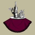 Bottle of wine with a glass, bunch of grapes with leaves, metal tray on a round table and old ribbon banner Royalty Free Stock Photo