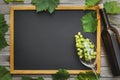 Bottle of wine with a glass and bunch of grapes with leaves on a wooden table with copy space. Wine business concept Royalty Free Stock Photo