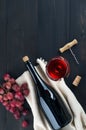 Bottle of wine, wine glass, grapes and corkscrew on dark background Royalty Free Stock Photo