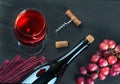 Bottle of wine, wine glass, grapes and corkscrew on dark table Royalty Free Stock Photo