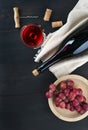 Bottle of wine, wine glass, grapes and corkscrew on dark table Royalty Free Stock Photo