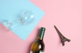 Bottle of wine, glass, statuette of Eiffel Tower on a colored pastel background. Top view. Minimalism