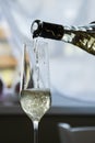A bottle of wine pours white wine in a wine glass Royalty Free Stock Photo
