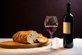 a bottle of wine, a slice of challah bread, and a kiddush cup on a table
