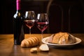 a bottle of wine, a slice of challah bread, and a kiddush cup on a table
