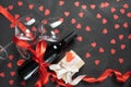 A bottle of wine and two large glasses on a black concrete background. box packed with a bow. valentine`s day concept Royalty Free Stock Photo