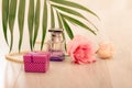 Bottle of woman perfume with gift box, leaves and flowers on pink background Royalty Free Stock Photo