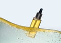 The bottle of the yellow cosmetic oil in the oil emulsion wave