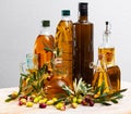 Bottled olive oil and branches with leaves and olives