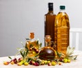 Bottled olive oil and branches with leaves and olives