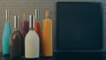 Bottles of alcoholic beverages different colors and size. Menu board and old brick wall background.