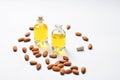 Bottles of almond oil and almonds on white background, copyspac Royalty Free Stock Photo