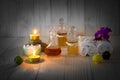 Bottles of aromatic oils with candles, pink orchid, stones and white towel on vintage wooden background with vignette Royalty Free Stock Photo