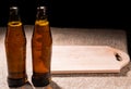 Bottles of Beer and Wooden Cutting Board on Table Royalty Free Stock Photo