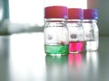 Bottles and blue cap with green, red and clear solution buffer pH 4, 7 and 10 on bench laboratory for analysis and calibrate.