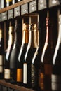 Bottles of champagne on the shelf, close-up image of alcoholic beverages in the wine cellar. Close-up image. Royalty Free Stock Photo