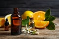 Bottles of citrus essential oil on wooden table. Space for text