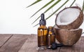 Bottles of coconut aromatic oils on a wooden table with a copy of the space