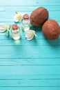 Bottles with coconut oil on bright wooden background. Royalty Free Stock Photo