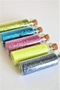 Bottles of Colorful Glitter on a White Background Isolated