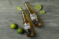 Bottles of Corona Extra and lime on gray textured background