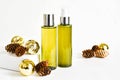 Bottles cosmetic product on a white background with golden Christmas balls, fir cones. SPA natural beauty products. Natural beauty