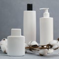 Bottles for cosmetics and twig of cotton. Blank mockups of white plastic cosmetics bottles. Body care concept.