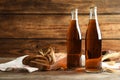 Bottles of delicious fresh kvass, spikelets and bread on wooden table