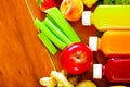 Bottles of delicious organic juice lying on desk sorrounded by fruits and veggies, beautiful colors, healthy lifestyle Royalty Free Stock Photo