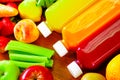 Bottles of delicious organic juice lying on desk sorrounded by fruits and veggies, beautiful colors, healthy lifestyle Royalty Free Stock Photo