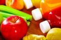 Bottles of delicious organic juice lying on desk sorrounded by fruits and veggies, beautiful colors, healthy lifestyle Royalty Free Stock Photo