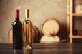 Bottles of delicious wine and blurred barrels Royalty Free Stock Photo