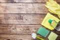 Bottles with detergents, brushes and sponges on wooden background. Colorful cleaning products. Home cleaning concept. Top view, Royalty Free Stock Photo