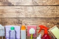 Bottles with detergents, brushes and sponges on wooden background. Colorful cleaning products. Home cleaning concept. Top view, Royalty Free Stock Photo
