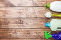 Bottles with detergents, brushes and sponges on wooden background. Colorful cleaning products. Home cleaning concept. Top view, Royalty Free Stock Photo