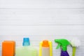 Bottles with detergents, brushes and sponges on wooden background. Colorful cleaning products. Home cleaning concept. Top view, Royalty Free Stock Photo